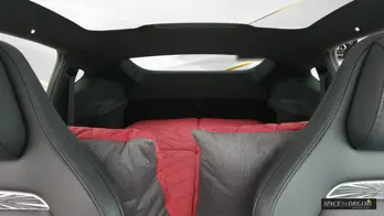 Regarder vers l'arrière depuis l'avant présente une chambre à coucher rose sans défaut ; la structure ferme en polyuréthane ne bouge pas avec les mouvements, ce qui est extrêmement agaçant avec les lits gonflables légers.